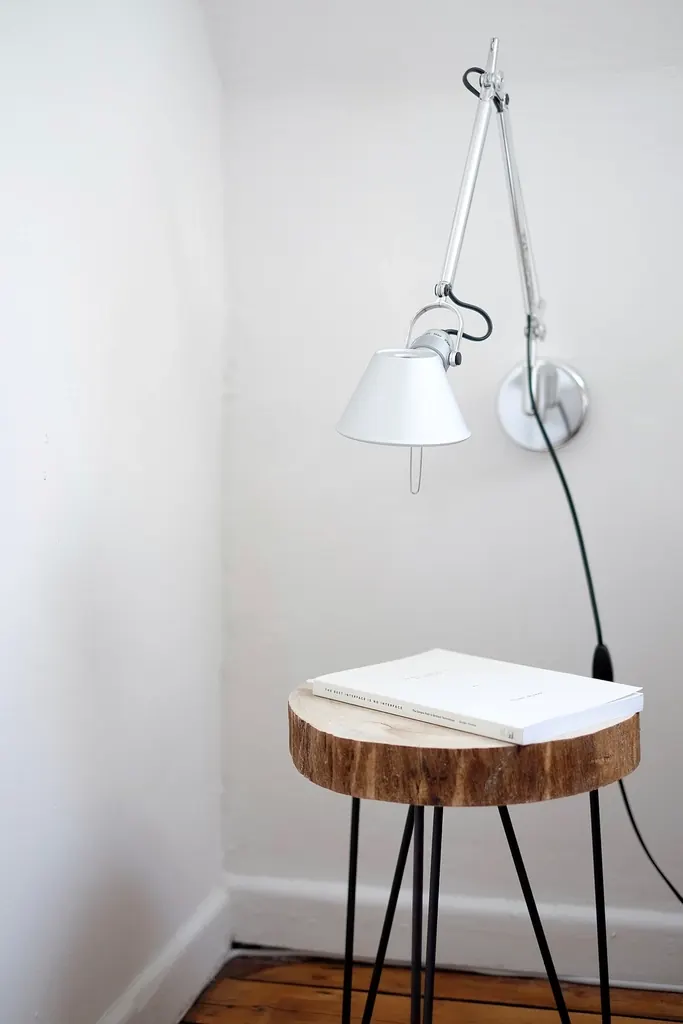 Kabu side table — a tree-stump oak side table beside a wall lamp